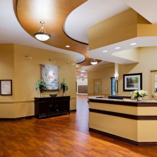 A modern reception area with wood flooring and elegant lighting.