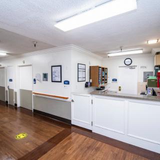 A clean and quiet hospital hallway featuring a nurse station.