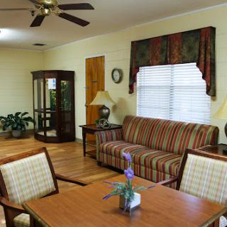 A cozy living room featuring a striped sofa, wooden dining table, and decorative touches.