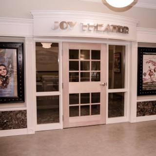 The entrance to a movie theater featuring promotional posters and a modern design.