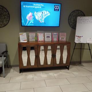 A waiting area featuring a digital information display and a brochure rack with various informational materials.