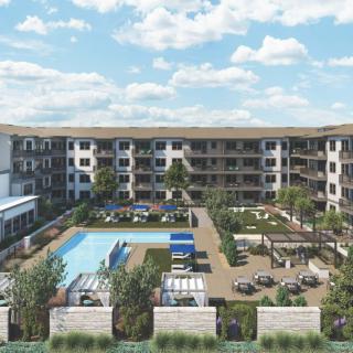 A modern apartment complex featuring a central courtyard with a swimming pool and landscaped outdoor areas.
