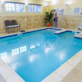 A cozy indoor swimming pool with seating and decor.