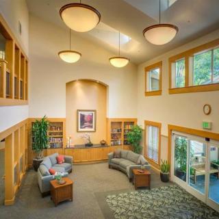 A spacious and well-lit lobby with modern furniture and greenery.