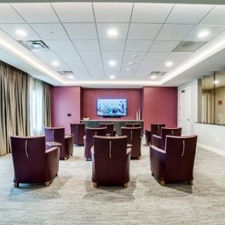 A modern conference room setup with seating and a television for presentations.