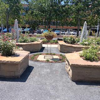 A serene garden space featuring decorative fountains and vibrant flower beds.
