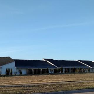 A wide view of a building featuring solar panels under a clear sky.