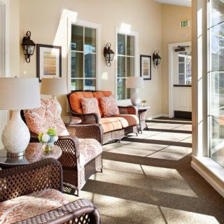 A cozy sunroom with wicker furniture and large windows letting in natural light.