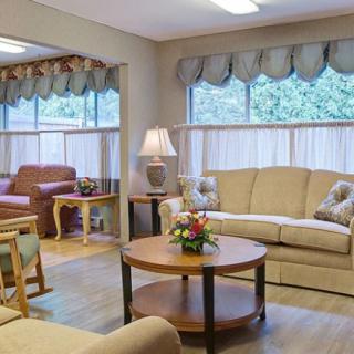 A cozy living room with sofas, a coffee table, and ample natural light.