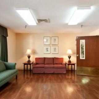 A cozy waiting room with sofas, lamps, and artwork on the walls.