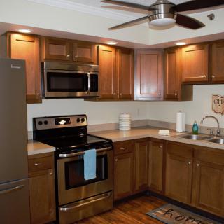 A modern kitchen with wooden cabinets and stainless steel appliances.