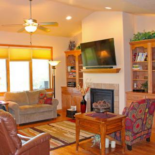 A cozy living room featuring a fireplace, comfortable seating, and ample natural light.