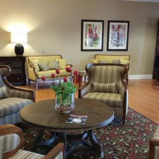 A cozy living room setup with armchairs, a sofa, and a coffee table adorned with flowers.