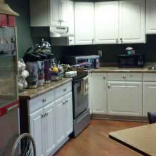 A kitchen with white cabinets and various appliances on the countertop.