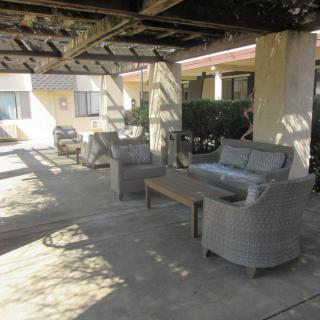 Outdoor patio with chairs and table under a pergola.