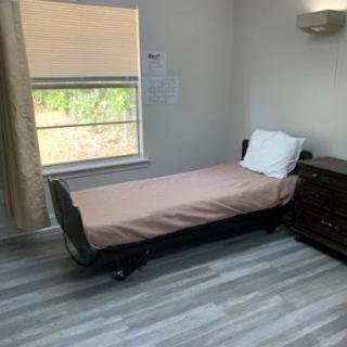 A minimalist bedroom with a single bed beside a window.