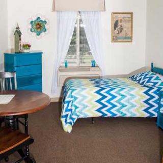 Cozy bedroom with blue-themed decor and furniture.
