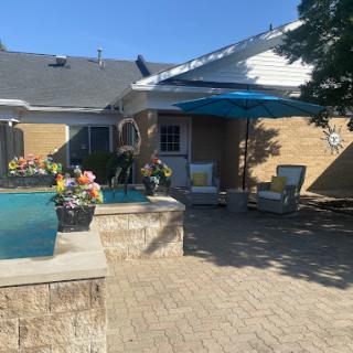 A serene backyard oasis featuring a sparkling pool and comfortable seating, perfect for sunny days.