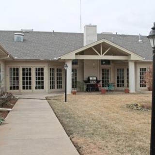 A single-story building with a covered patio and a walkway leading up to it.