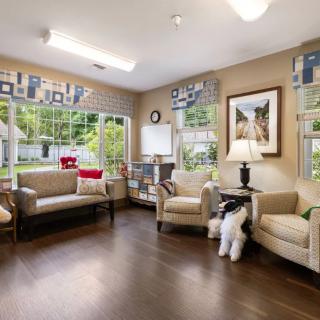 A cozy waiting room with comfortable seating and large windows.