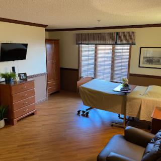 A well-furnished room featuring a bed, TV, and seating area, designed for comfort.