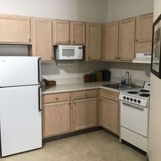 Cozy kitchen with essential appliances and wooden cabinets.