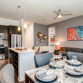 A modern open-plan apartment featuring a well-designed kitchen and dining area.