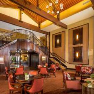 A cozy restaurant interior featuring elegant wooden beams and a spiral staircase.