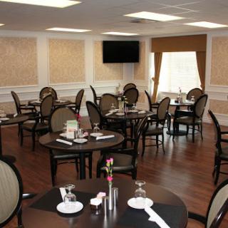 A spacious and elegantly designed dining area with well-set tables and comfortable seating.