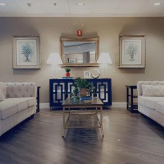 A well-decorated living room featuring two sofas, a central coffee table, and elegant lighting and artwork.