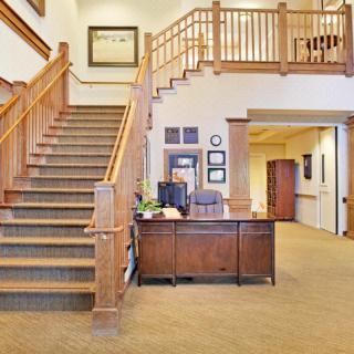 A welcoming reception area with a wooden staircase and desk.