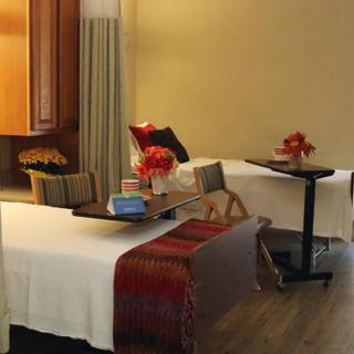A cozy hotel room with twin beds and elegant decor, featuring fresh flowers and a comfortable setting.