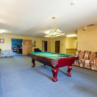 A spacious game room featuring a pool table and seating area.