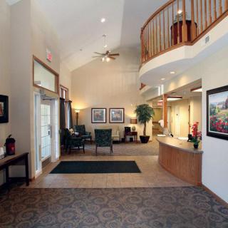 A modern lobby with a reception desk and seating area, featuring elegant decor.