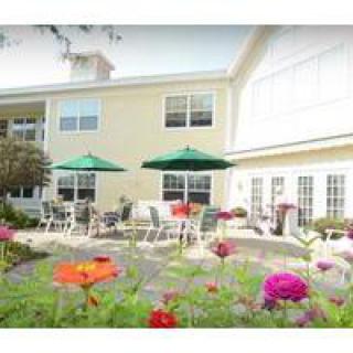 A charming outdoor patio area with colorful flowers and umbrella-shaded seating.