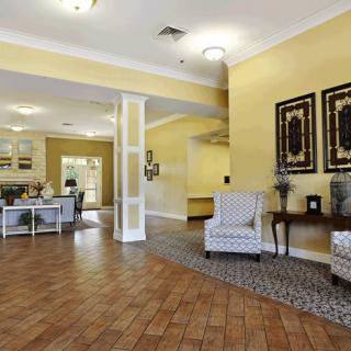 A spacious and inviting lobby with yellow walls, comfortable seating, and decorative artwork.