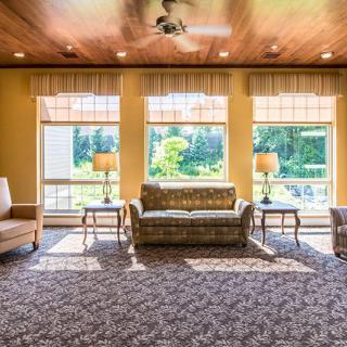 Spacious living room with large windows and classic furniture.