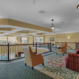 A cozy indoor lounge area with comfortable seating and a view over a balcony.