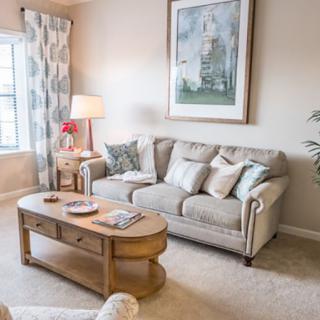 A cozy living room with a comfortable sofa, wooden coffee table, and elegant decor.