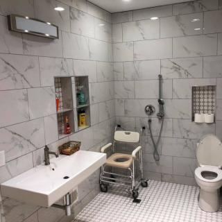 A modern, accessible bathroom equipped with a wheelchair-friendly shower area and toilet.
