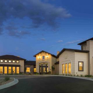 A residential house illuminated during twilight with a clear sky.
