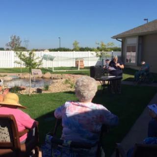 A group of seniors enjoying a sunny day in the backyard.