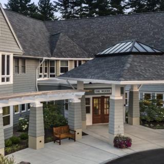 A view of a residential building with a covered entrance and well-maintained landscaping.