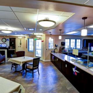 A modern dining area and kitchen with comfortable seating and bright lighting.