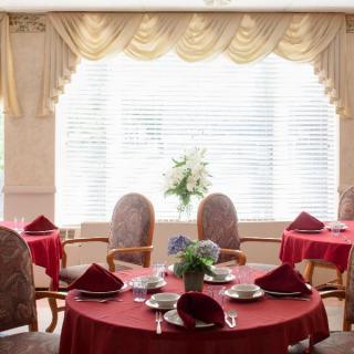 An elegant dining room with red tablecloths and neatly arranged tableware.