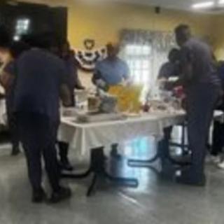 A group of people gathered around a table with food.