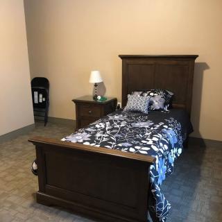 A minimalist bedroom with a single bed and nightstand.