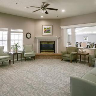 A cozy living room with a fireplace, ceiling fan, and comfortable seating.