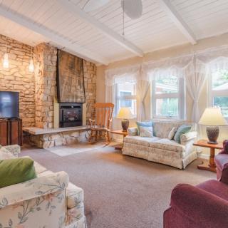 A cozy living room with a stone fireplace, comfortable sofas, and soft lighting.