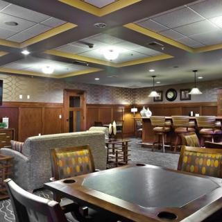 A cozy lounge area with comfortable seating, wooden accents, and warm lighting.